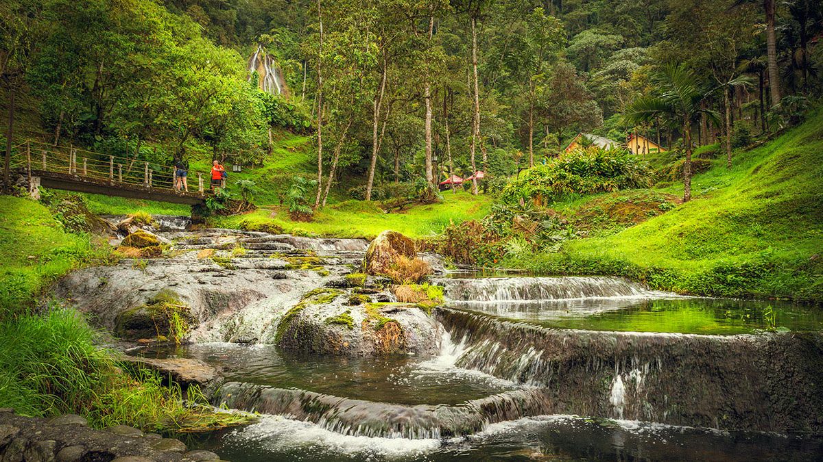 Waterfalls tumble down a green Andes mountainside at Santa Rosa de Cabal, in Colombia's coffee region.